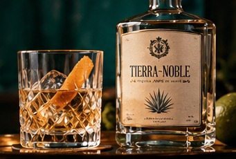 Illustrative Tierra Noble-style bottle and a single glass against a dark racing-green background.