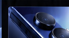 Close-up visual study of two round black camera elements on a cobalt phone.