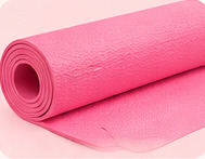 Rolled vivid pink exercise mat with textured surface