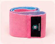 Pink resistance band rolled beside a dark woven label, cropped from the supplied promotional artwork.